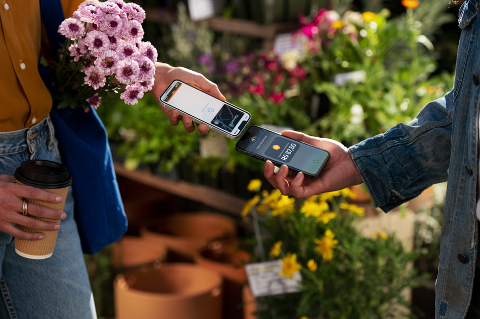 Customer and merchant bring their iPhones together to complete a contactless payment.