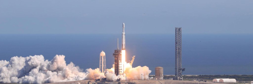 Falcon Heavy rocket carrying Europa Clipper rises from Kennedy Space Center amid fire and smoke.